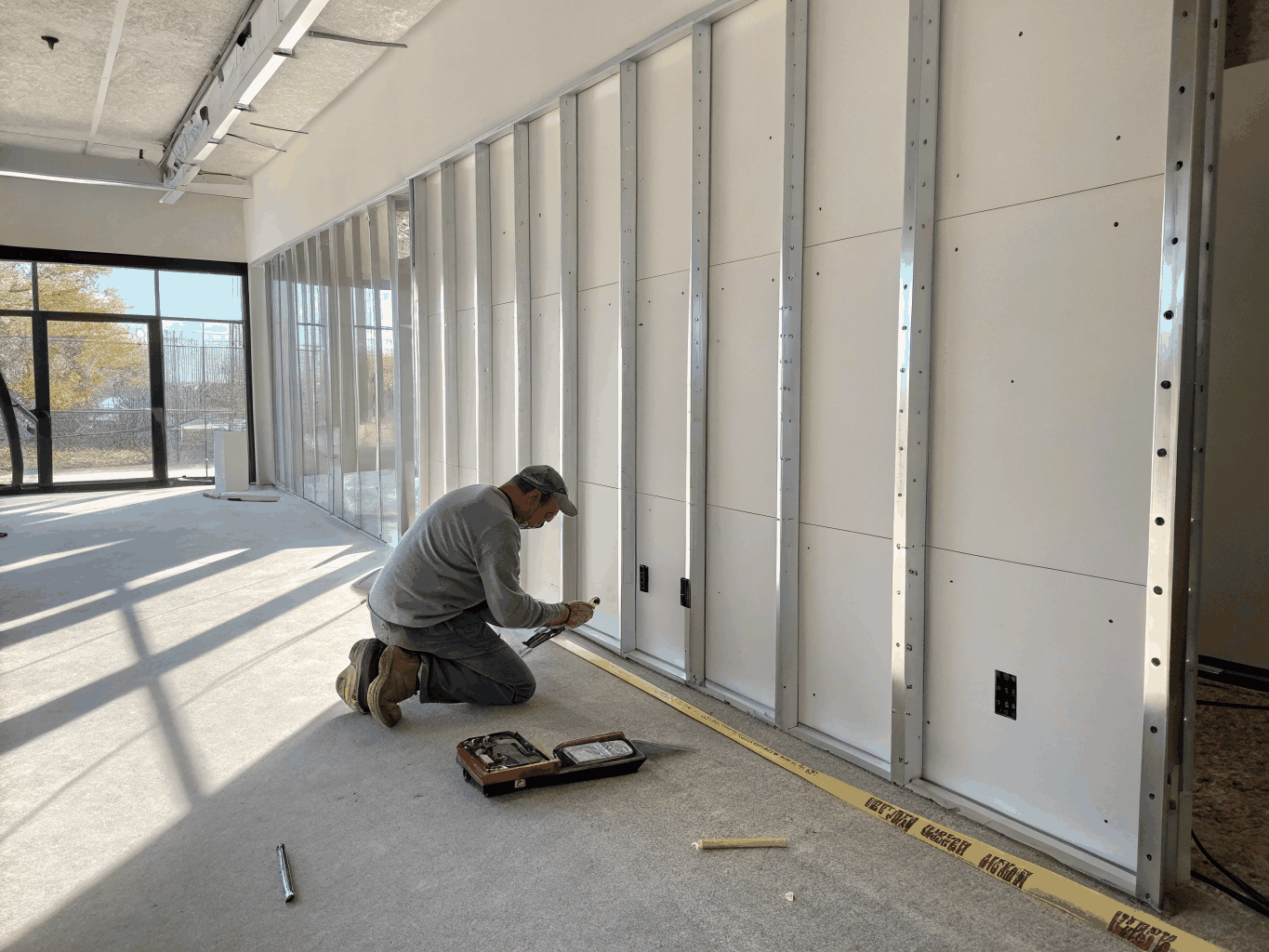 Carpenters installing new drywall and structural studs during property reconstruction